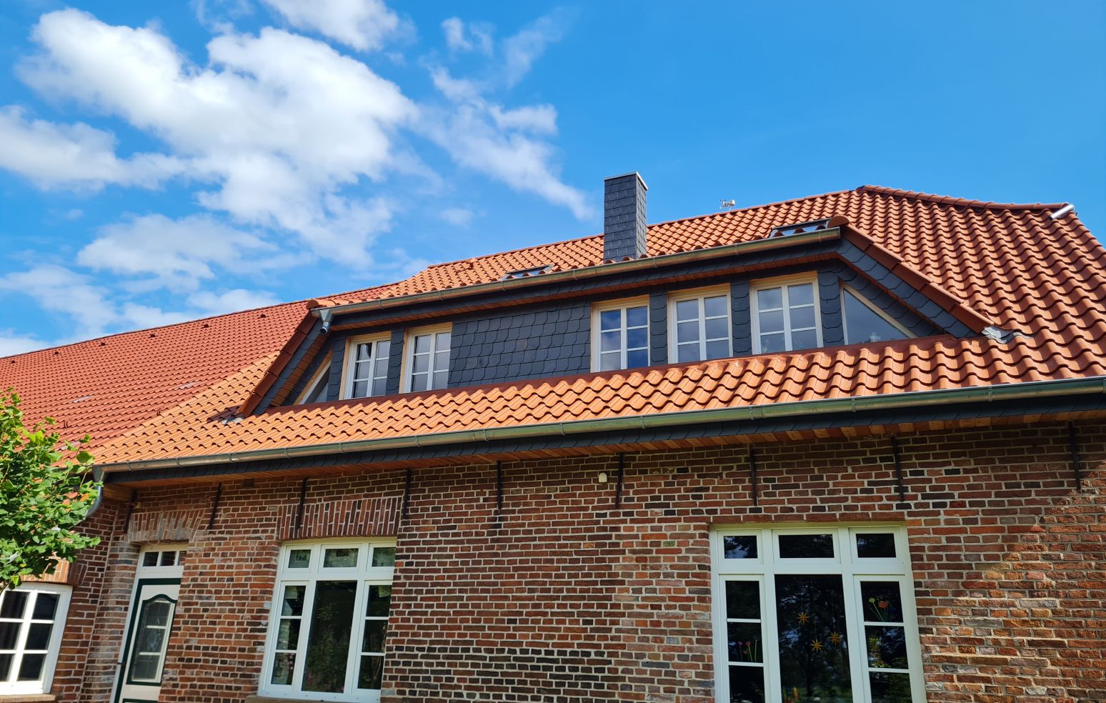 Außenansicht von einem Backsteinhaus mit einem Ziegeldach